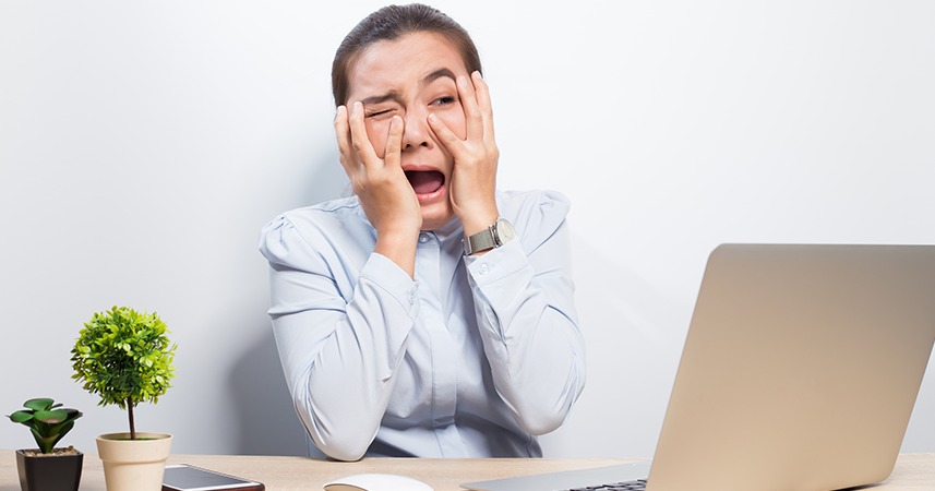 scared office worker looking at laptop